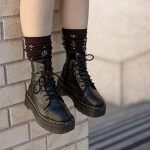 Merino Wool Socks styled with black combat boots on a brick wall, showcasing their unique personality and cozy warmth.