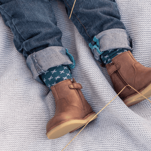 Baby wearing Lamington merino knee high socks in deep teal with light blue cross pattern made in New Zealand.