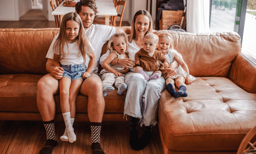 Family enjoying cozy time at home wearing mothers day merino socks gift on a comfortable couch.