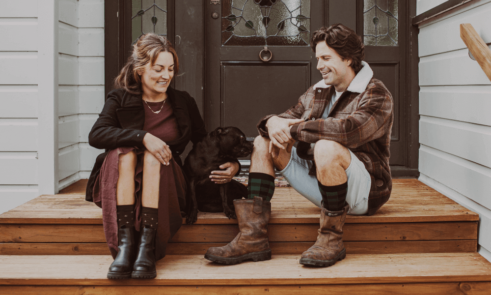Couple wearing stylish socks with their dog on the porch
