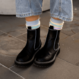 Woman wearing black leather boots with Merino Wool Socks in pastel colors.